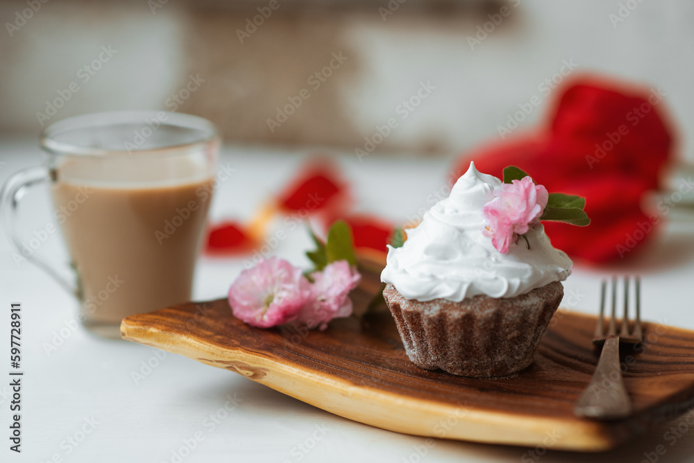 Cake and Coffee. Tasty cake with cream and pink flower decor in wooding plate. Red flowers on background Cake and Coffee. Tasty cake with cream and pink flower decor in wooding plate. Red flowers on background