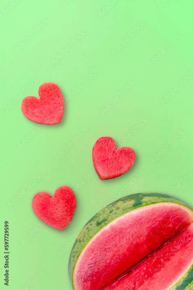 Obraz premium Cut watermelon and watermelon hearts on a green background