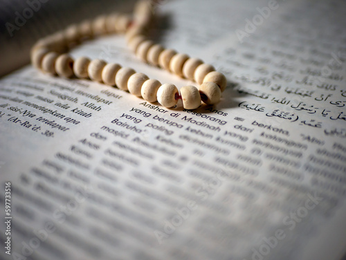White prayer beads on an Islamic book, selected focus