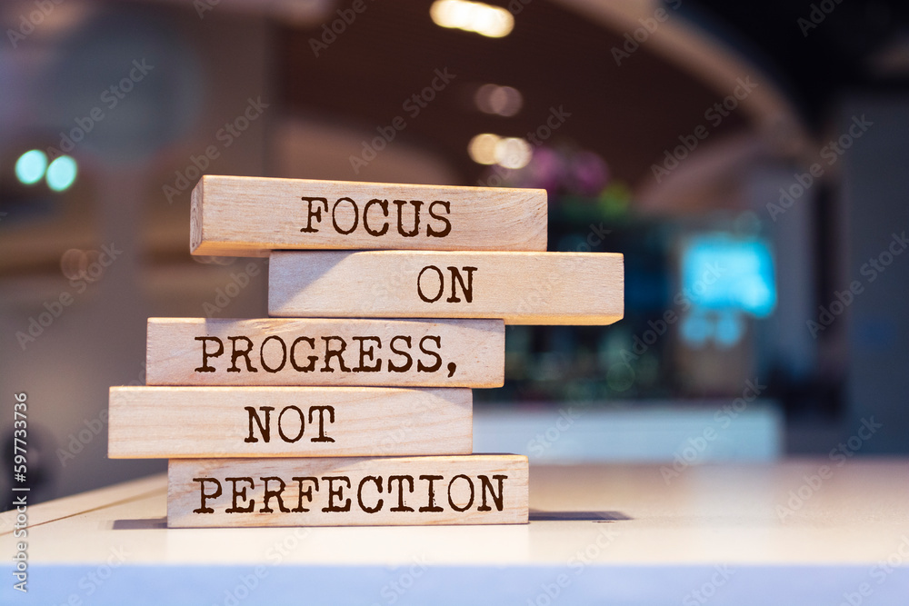 Wooden blocks with words 'Focus on progress, not perfection'. Inspirational motivational quote