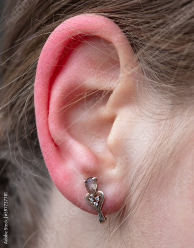 Girl's ear and earring. Close-up.