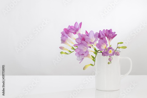 Fototapeta Naklejka Na Ścianę i Meble -  purple freesia in glass vase on white background