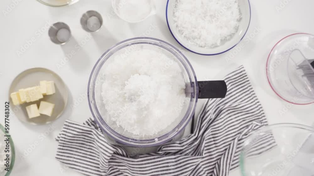 Time lapse. Flat lay. Mixing ingredients in a food processor to prepare homemade coconut cookies. Time lapse. Flat lay. Mixing ingredients in a food processor to prepare homemade coconut cookies.
