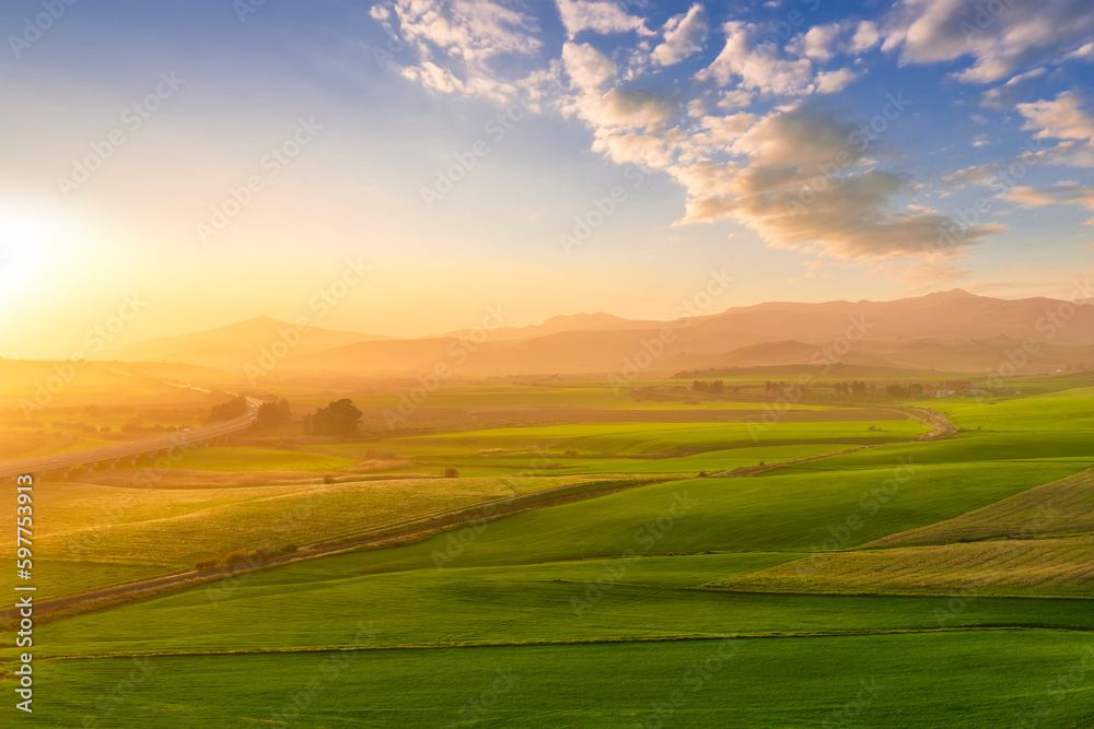 scenery rural view of a contryside farm in green fields and hills with amazing cloudy sky on background scenery rural view of a contryside farm in green fields and hills with amazing cloudy sky on background