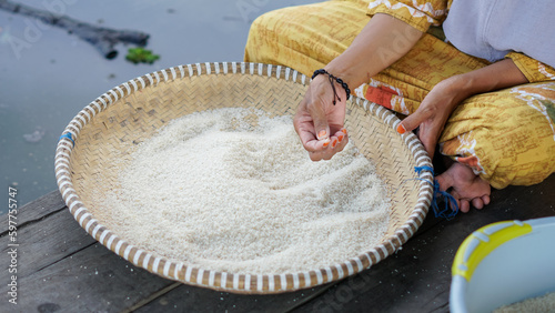 Banjar mothers in a rural village winnowing rice using a traditional basket called 