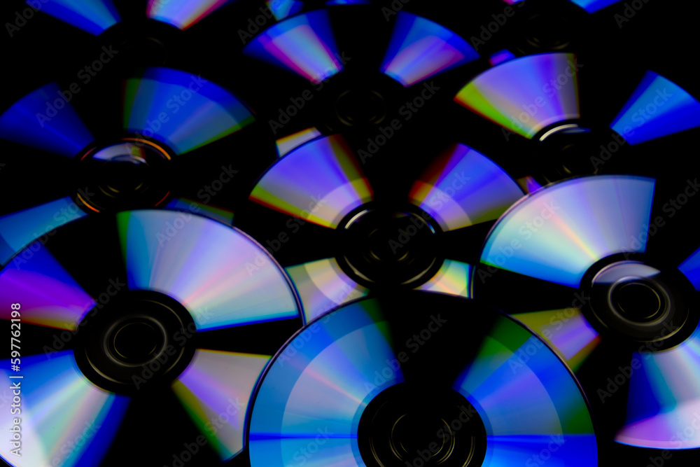 CD and DVD isolated on black background with colorful light reflections CD and DVD isolated on black background with colorful light reflections