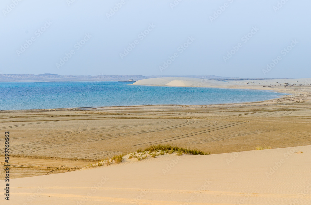 Sand dunes descending into the creek at Al-Adaid Desert in Qatar