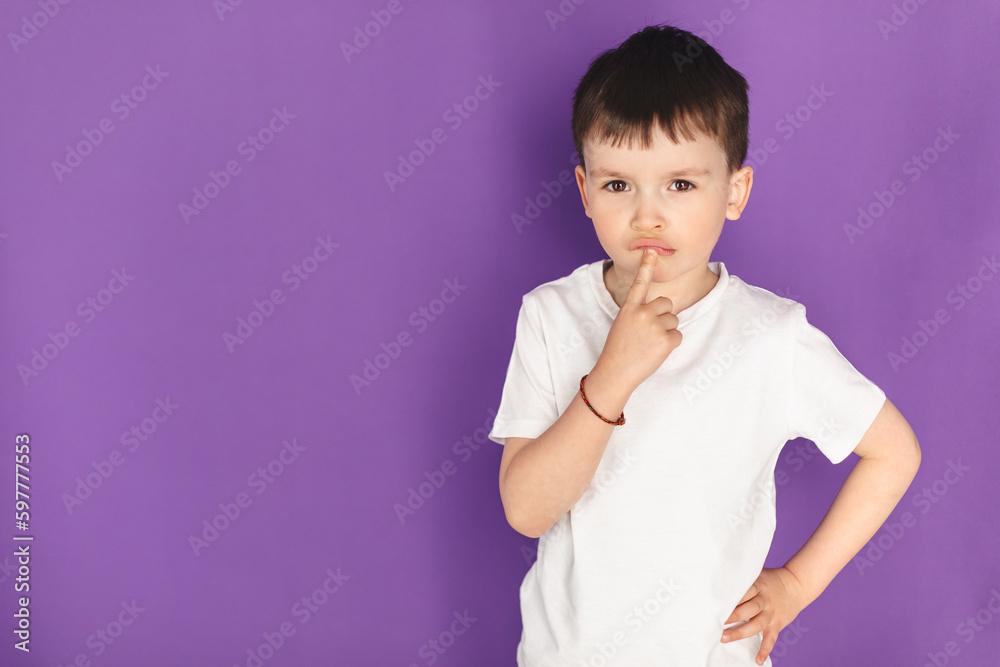 Attractive brunette boy wear white t shirt standing thinking on purple background isolated, Cute little man look at camera and copy space. Thinking boy, search solution. Attractive brunette boy wear white t shirt standing thinking on purple background isolated, Cute little man look at camera and copy space. Thinking boy, search solution.