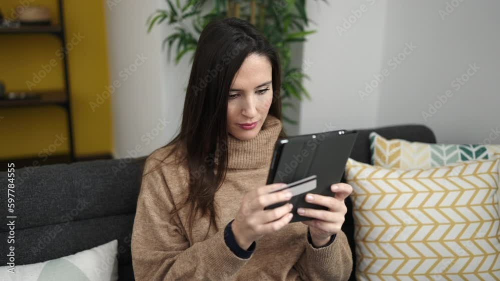 Beautiful hispanic woman doing online shopping with tablet at home Beautiful hispanic woman doing online shopping with tablet at home