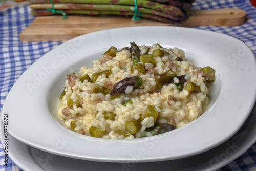 Dish with risotto of green asparagus and pieces of sausage.