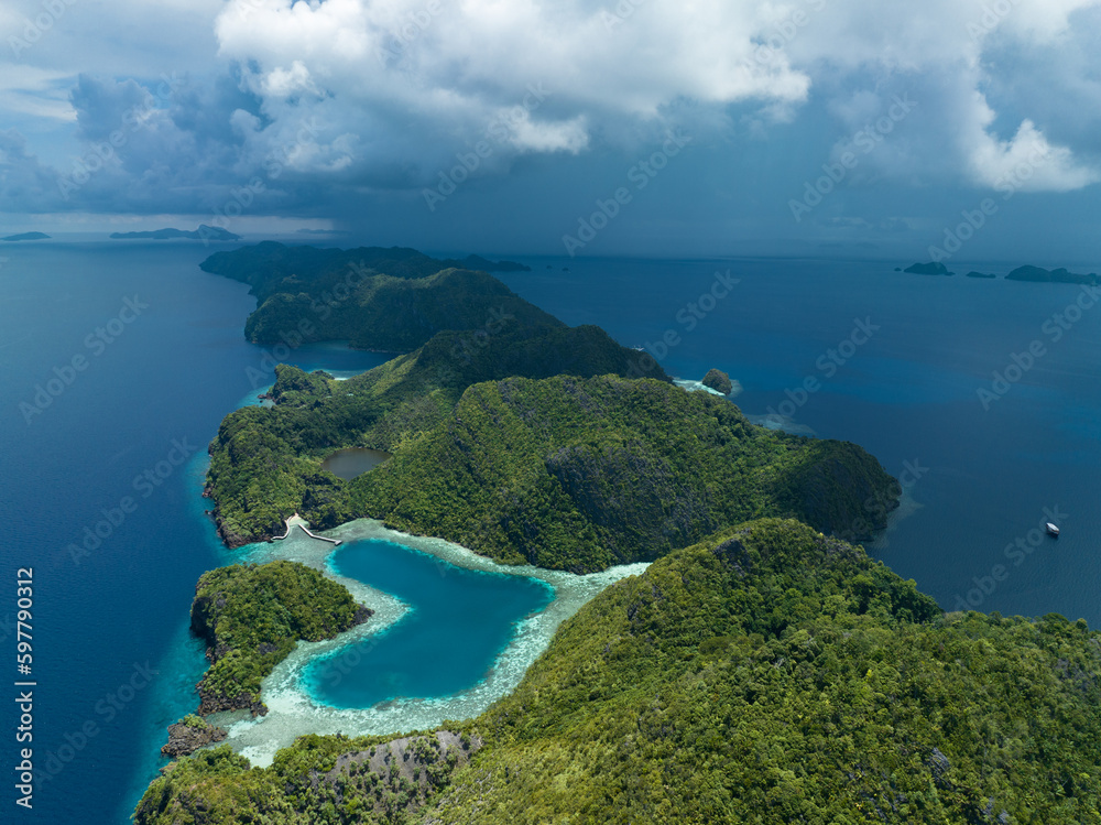 A heart-shaped lagoon is surrounded by dramatic limestone islands that rise from Raja Ampat's seascape in Misool. This remote part of Indonesia is known for its incredible marine biodiversity.