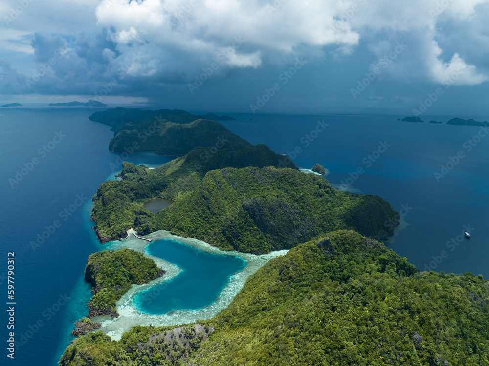 A heart-shaped lagoon is surrounded by dramatic limestone islands that rise from Raja Ampat's seascape in Misool. This remote part of Indonesia is known for its incredible marine biodiversity. A heart-shaped lagoon is surrounded by dramatic limestone islands that rise from Raja Ampat's seascape in Misool. This remote part of Indonesia is known for its incredible marine biodiversity.