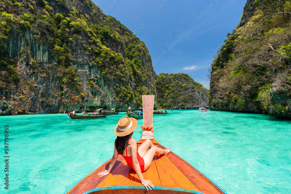 Young woman traveler relaxing and enjoying at Pi leh Lagoon at ko Phi Phi lay island in Krabi, Thailand, Summer vacation and Travel concept - obrazy, fototapety, plakaty 