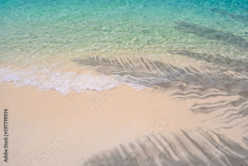 Fototapeta Naklejka Na Ścianę i Meble -  Beautiful tropical white sand beach with shadow of leaves, Summer vacation and Travel background with copy space