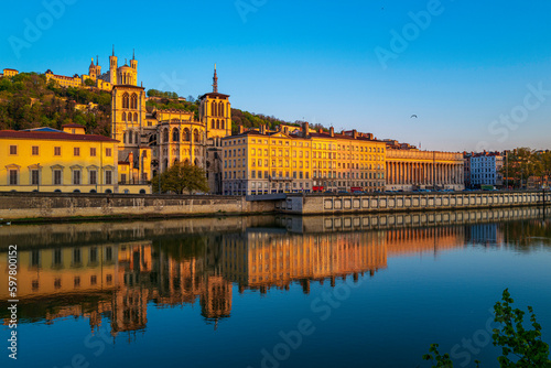 Lyon city skyline, buildings, and landmark architectures at sunrise with water reflections in the Saone River in France