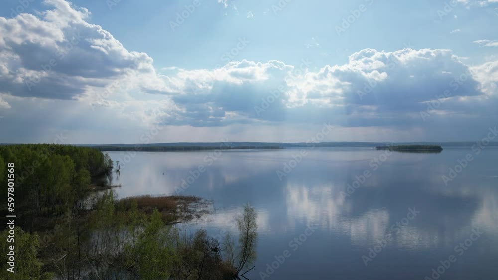 Separate islands are visible on the floods of the Volga River. The rays of the sun break through the clouds. Separate islands are visible on the floods of the Volga River. The rays of the sun break through the clouds.