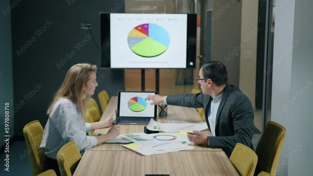 Close-up shot of successful businesspeople collaborating together. Young caucasian male and female entrepreneurs analyzing financial reports. High quality 4k footage Close-up shot of successful businesspeople collaborating together. Young caucasian male and female entrepreneurs analyzing financial reports. High quality 4k footage