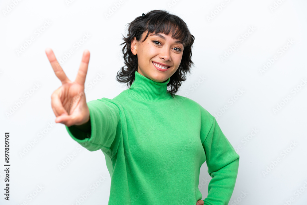 Young Argentinian woman isolated on white background smiling and showing victory sign Young Argentinian woman isolated on white background smiling and showing victory sign