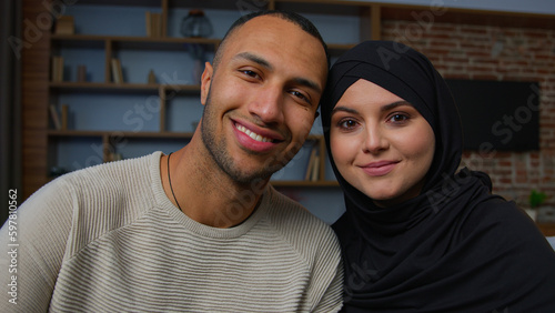 Spouses family multiracial diverse ethnicity couple man african american husband and arabian muslim woman wife smiling multiethnic girlfriend boyfriend posing together 30s happy homeowners portrait