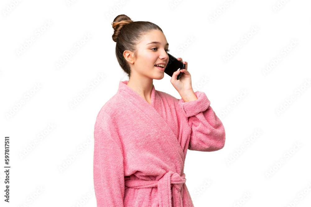 Teenager girl in a bathrobe over isolated chroma key background keeping a conversation with the mobile phone Teenager girl in a bathrobe over isolated chroma key background keeping a conversation with the mobile phone