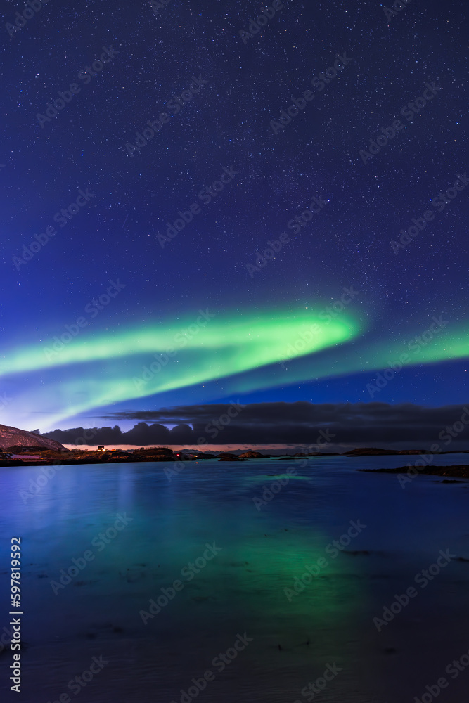 Aurora Borealis over Norway's Sommaroy Peninsula in March, vertical