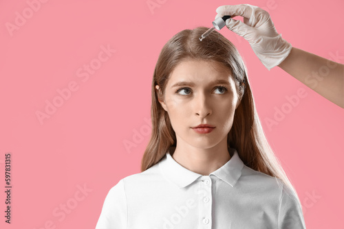 Cosmetologist applying seru...