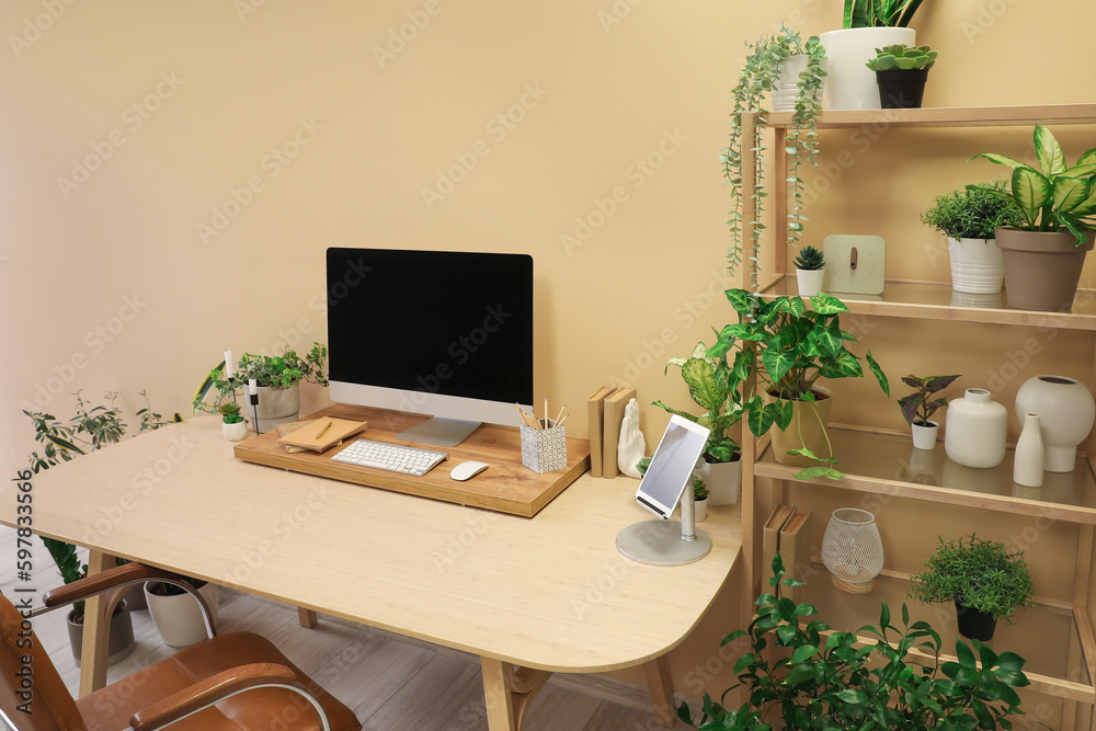 Interior of office with workplace, shelving unit and houseplants Interior of office with workplace, shelving unit and houseplants