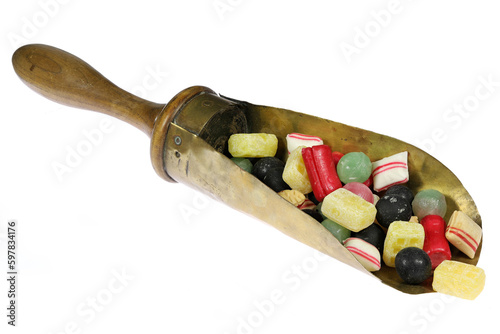 classic Dutch candies in a vintage brass weighing scoop isolated on white background photo