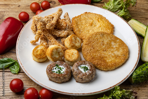 A plate of fried meats with a fried chicken and fried potato.