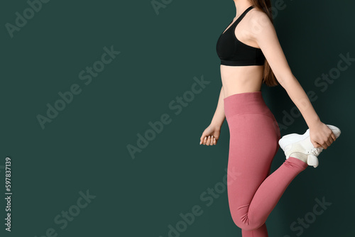Canvas Print Sporty young woman in leggings on green background