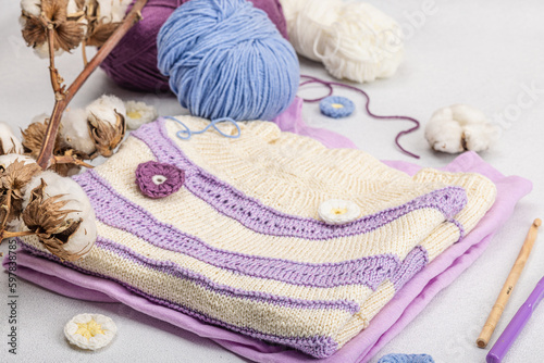 Handmade crocheted baby t-shirt in lilac tones. Stuff contains thread, hooks, knitting needles