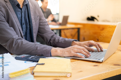 Closed up young smart businessman officer employee working typing on laptop computer