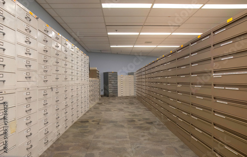 Obraz na plátne Rows of  beige and brown filing cabinets in an empty office with fluorescent lig