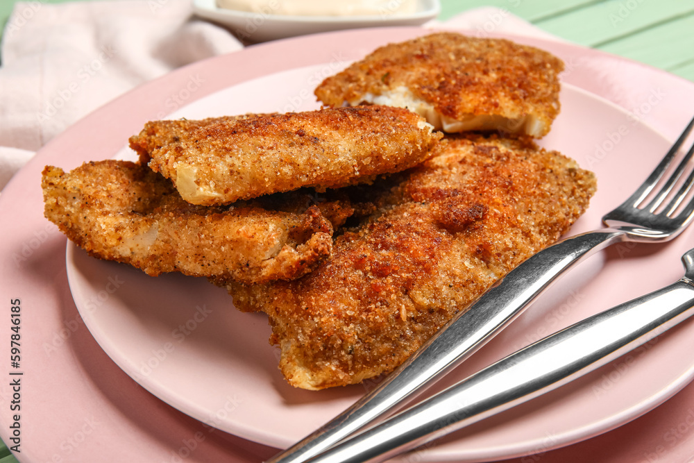 Plates of tasty fried codfish on table, closeup