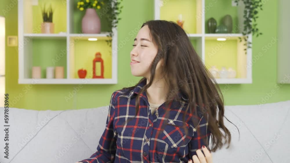 Happy beautiful asian young woman sniffing her long hair at home. Happy beautiful asian young woman sniffing her long hair at home.