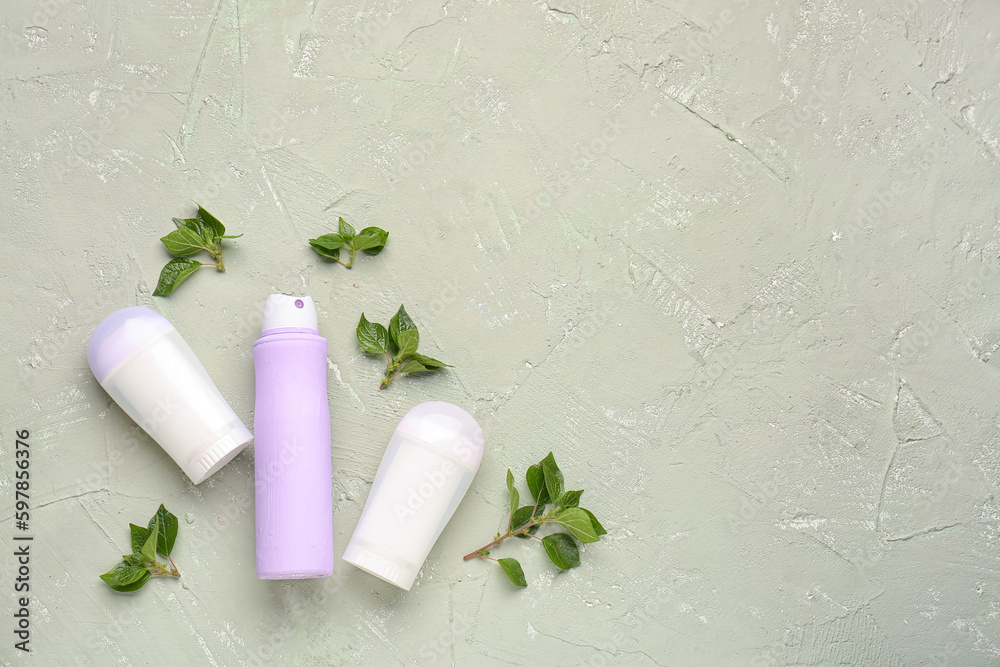 Different deodorants and leaves on grunge background Different deodorants and leaves on grunge background