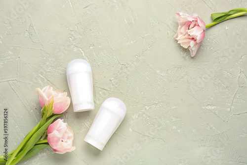 Deodorants and flowers on grunge background