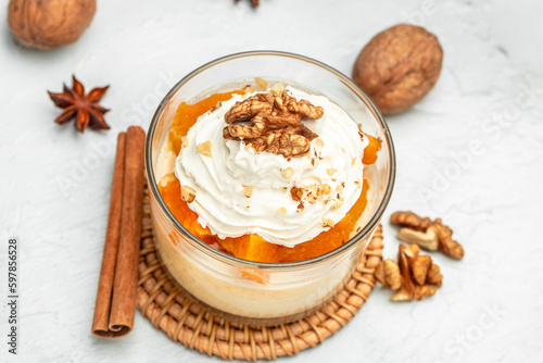 Pumpkin parfait with nuts in glass on a light background. banner, menu, recipe place for text, top view
