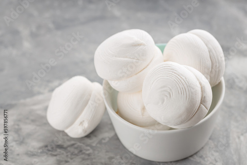 Marshmallows in bowl on a gray background. Sweet dessert zephyr marshmallows on concrete. Close up