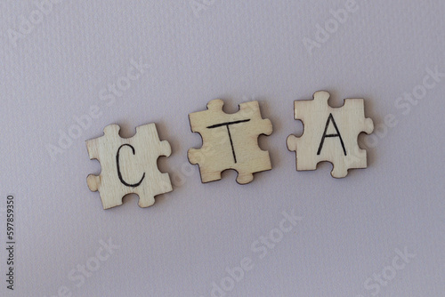 The acronym CTA, which stands for Call To Action. The letters written on the puzzles.