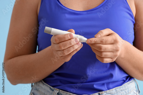 Woman with diabetes using lancet pen  closeup