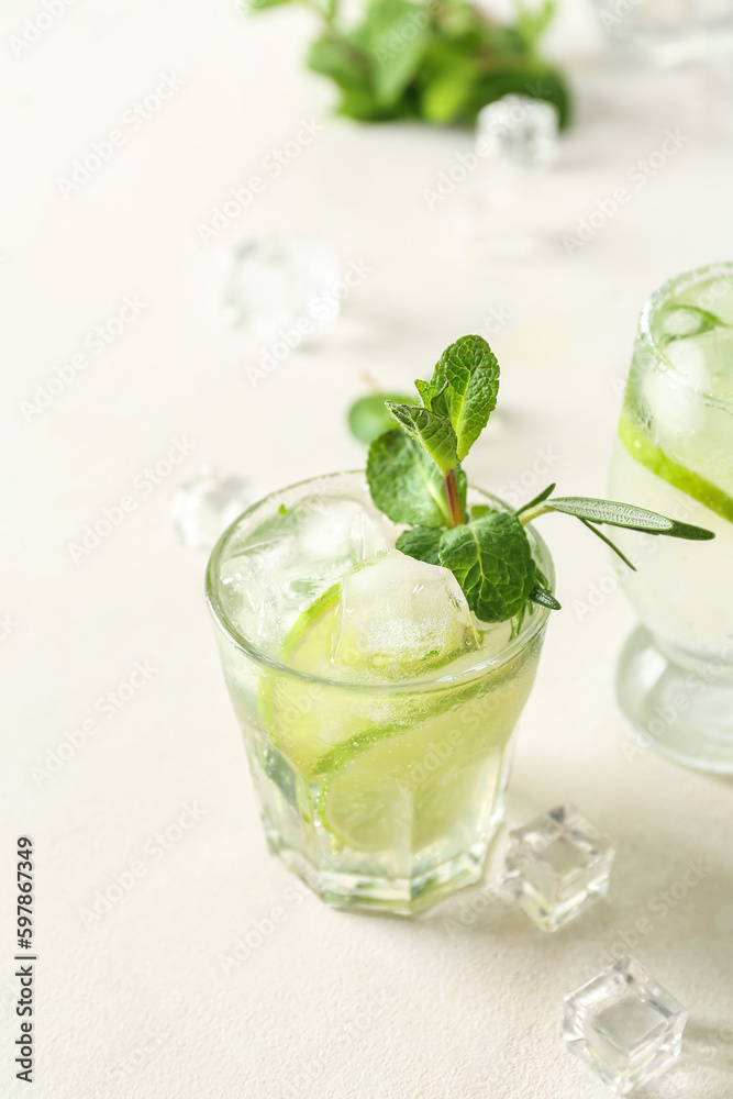 Glass of tasty mojito on light background