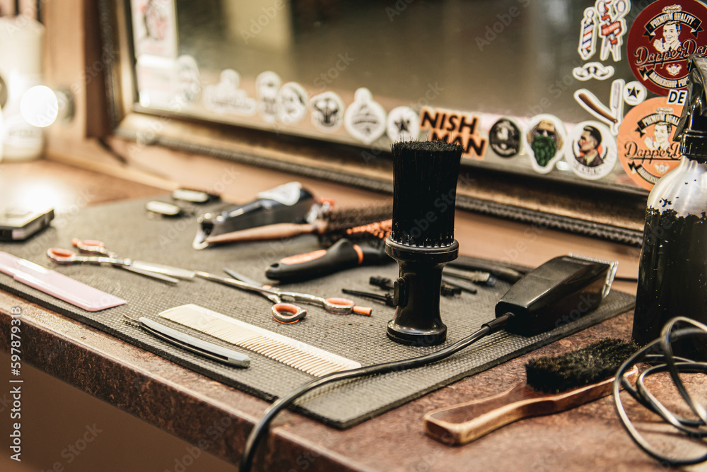 barber tools on wooden shelf and mirror in barbershop