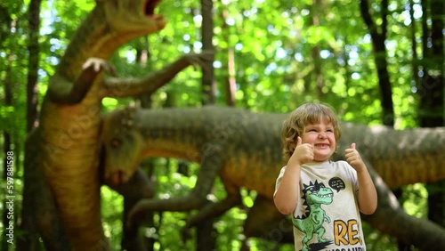 Little boy watching Exhibition of models of sculpture dinosaur in Dinopark