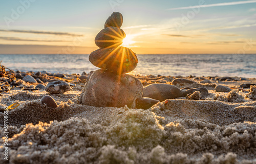 Steinpyramiden und Glaskugel am traumhaften Ostsee Sand Strand auf Rügen zum spektakulären Sonnenuntergang