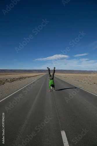 young man walks with his hands on a lonely path in the desert of patagonia. cross fit