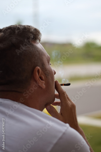 Middle aged man smoking cannabis joint
