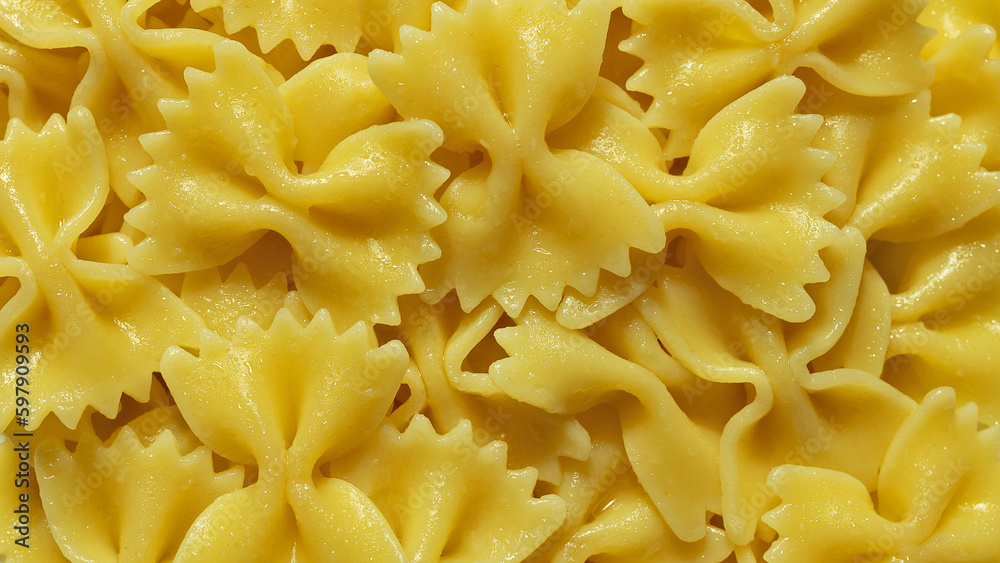Background yellow pasta in shape of butterflies close-up Background yellow pasta in shape of butterflies close-up