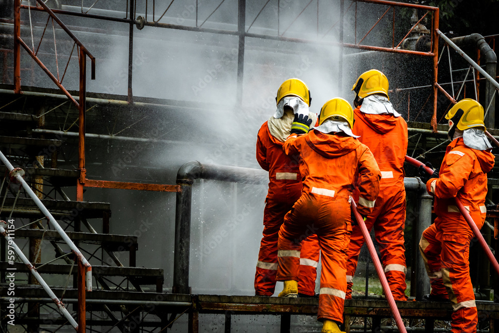 Firefighter Concept. Fireman using water and extinguisher to fighting with fire flame. firefighters fighting a fire with a hose and water during a firefighting training exercise Firefighter Concept. Fireman using water and extinguisher to fighting with fire flame. firefighters fighting a fire with a hose and water during a firefighting training exercise