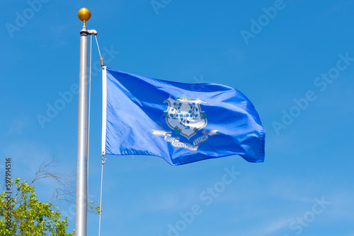 Flag of Connecticut against blue sky in village of Mystic, Stonington, Connecticut CT, USA.  photo